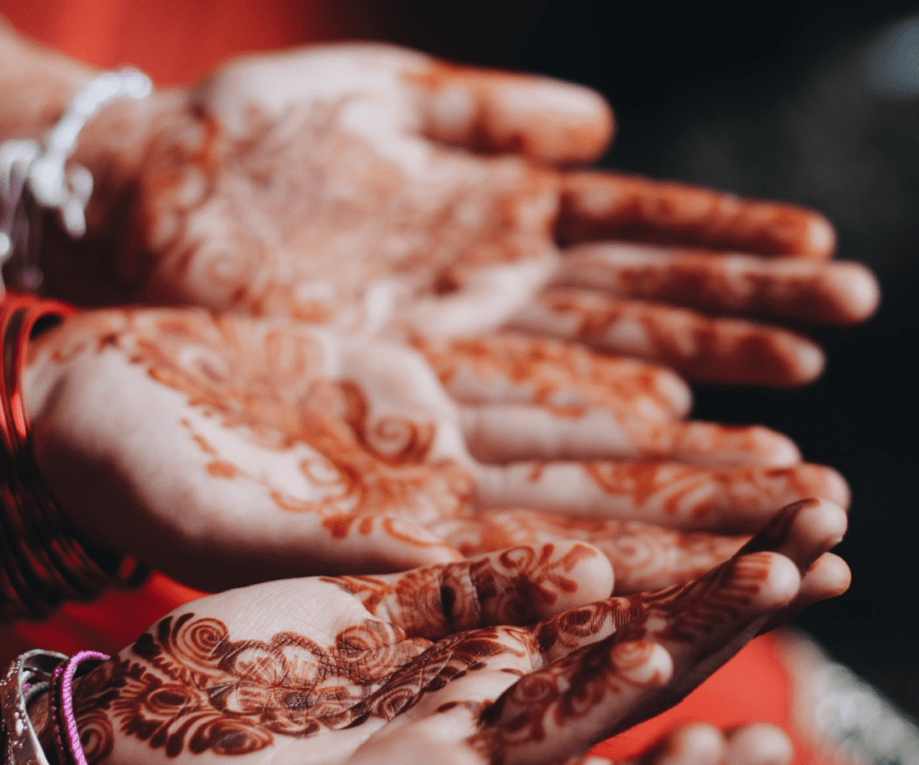 Women adorn their palms with Henna